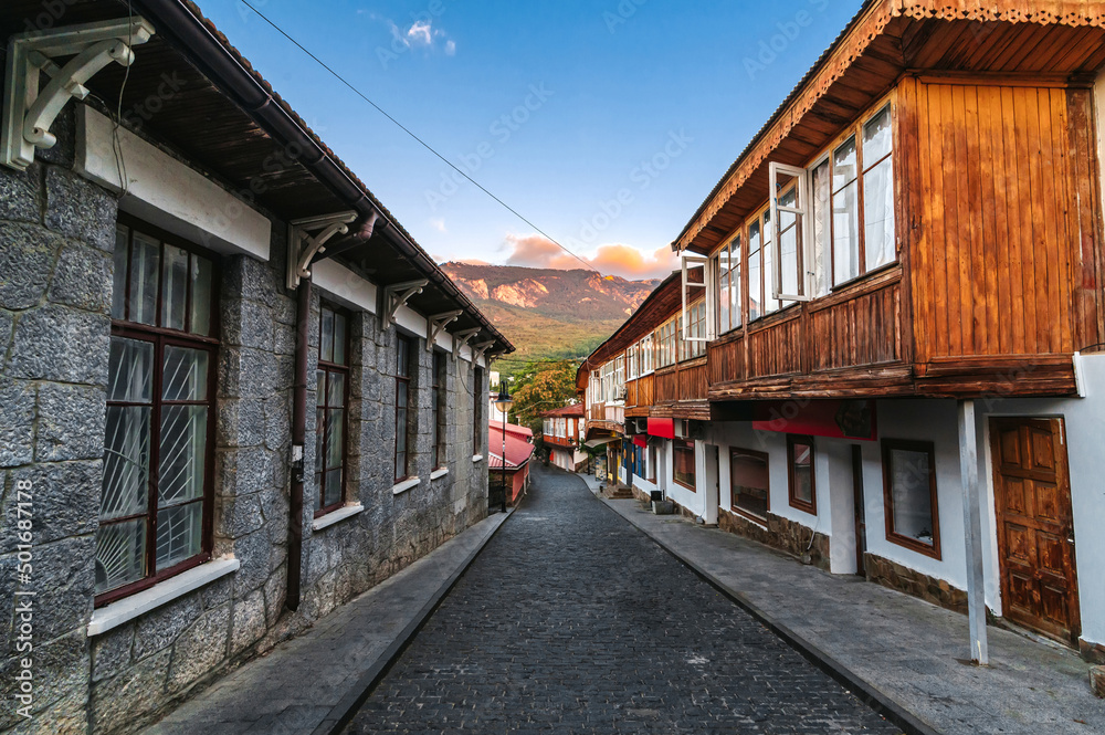 beautiful street with stone historical houses and paving stones against the backdrop of mountains in the resort of Gurzuf in the Crimea