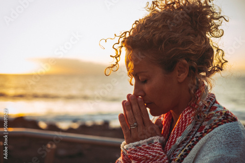 Canvastavla Meditation and inner balance interior happiness concept with side portrait of young woman praying and meditating outdoor with sunset ocean in background