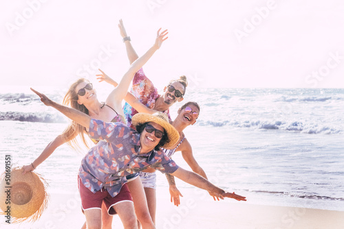 Group of friends tourist have fun and play together at the beach with sea water in background. Cheerful and happy group of people in outdoor leisure activity in summer holiday vacation lifestyle