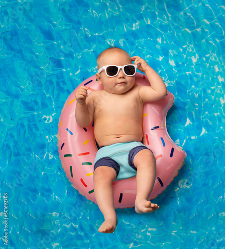 small child swims in the pool on an inflatable ring