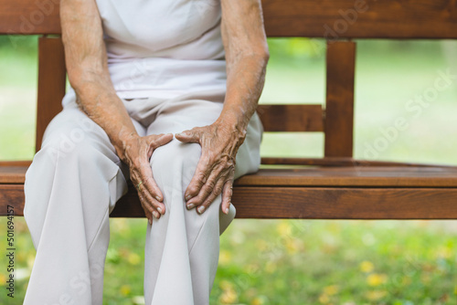 Canvas Print Senior woman holding her painful knee