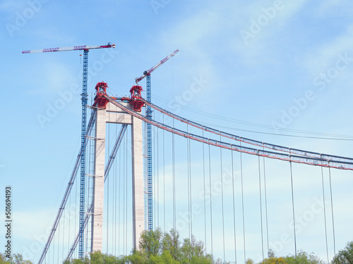 Suspension bridge under construction with crane