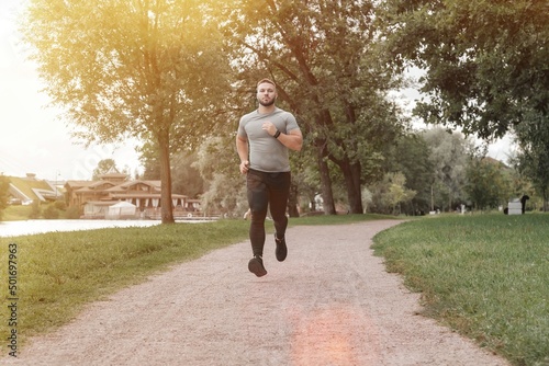 Man sportsman runner running in park training and exercising