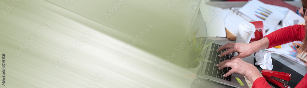 Businesswoman working on a messy desk; panoramic banner
