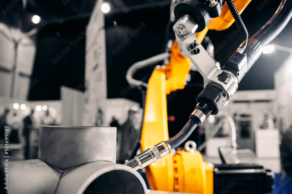 Fototapeta premium CNC automatic arm robot welding metal pipe part in industry factory