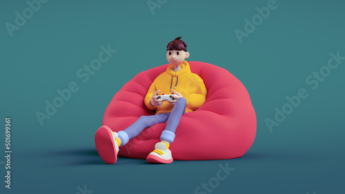 Tela Happy positive brunette guy wears a yellow hoodie, blue jeans holds a white gamepad in his hands plays video games sitting on red bean bag in relaxed pose