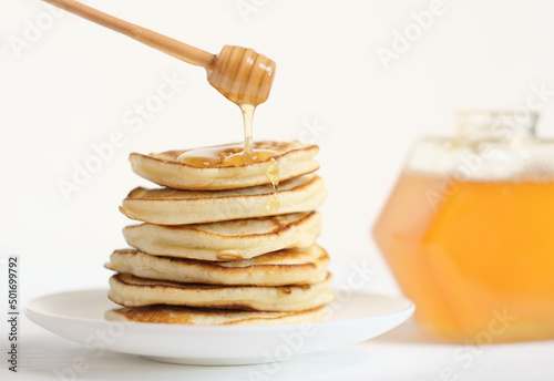 homemade pancakes in a stack and pouring honey, good morning, family breakfast. fresh harvested farmer's honey.