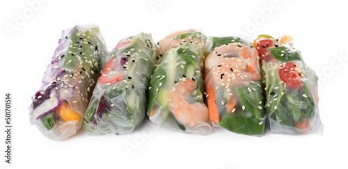 Many different rolls wrapped in rice paper on white background photo