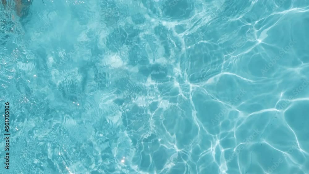 Topdown view of Boy in yellow trunks swims along Translucent water on Swimming pool Topdown view of Boy in yellow trunks swims along Translucent water on Swimming pool