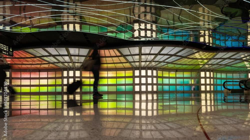 Passengers passing the illuminated tunnel at Chicago O'Hare in USA