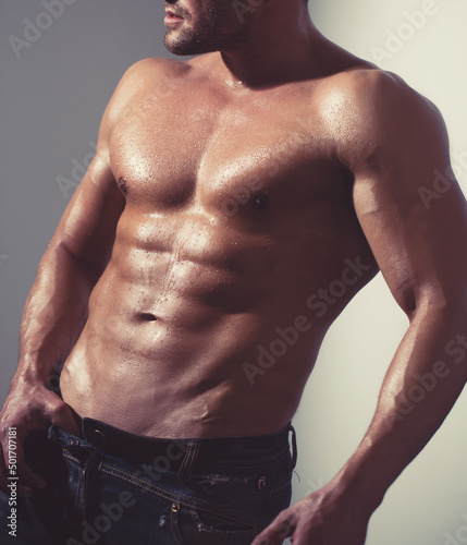 Strong athletic man fitness model torso showing six pack abs.