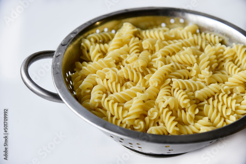 Boiled vermicelli noodles horns in a colander