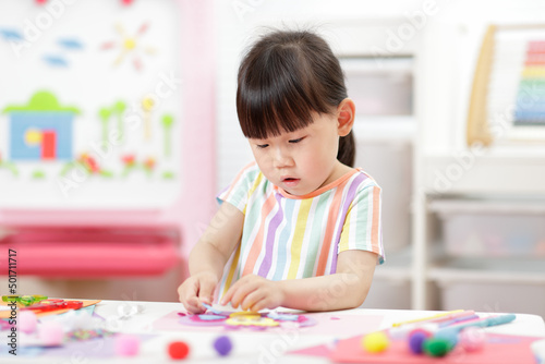 young girl making paper craft for homeschooling