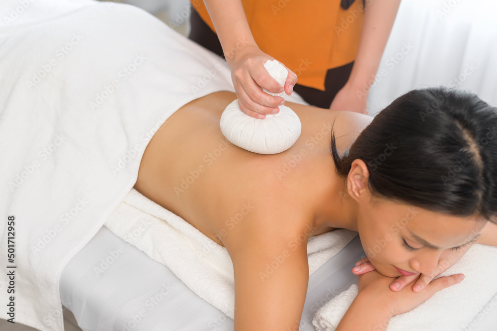 Young asian beautiful woman relaxing and enjoying massage, spa and beauty treatment concept