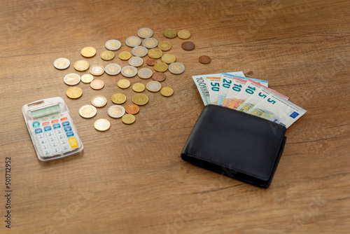 Banknoty euro i monety na stole z kalkulatorem i portfelem. Koncepcja finansów i budżetu.
