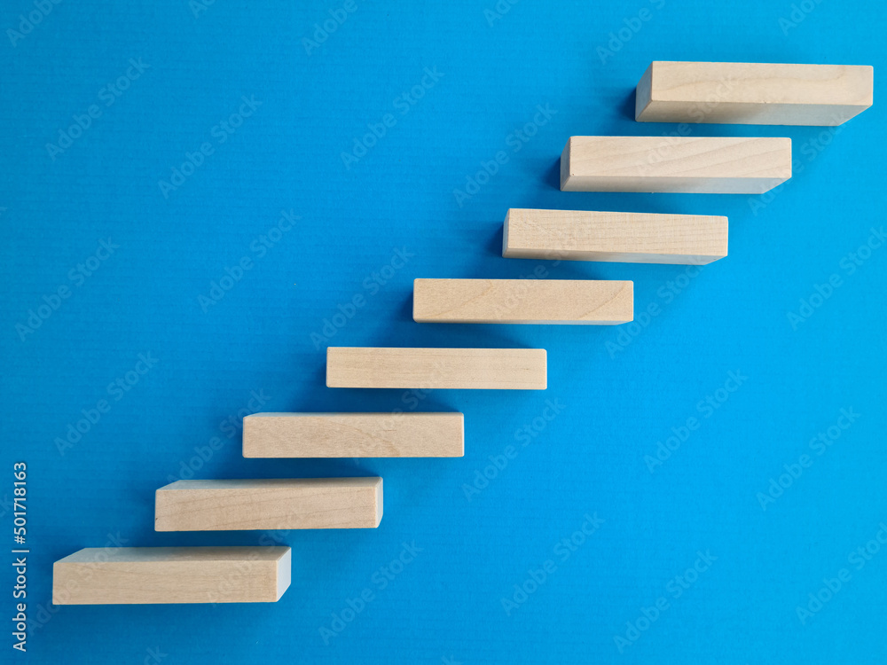 Wooden blocks in form of stairs on blue background Wooden blocks in form of stairs on blue background