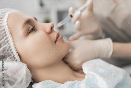 cosmetologist makes an injection at the client s nose. cosmetic wrinkle removal