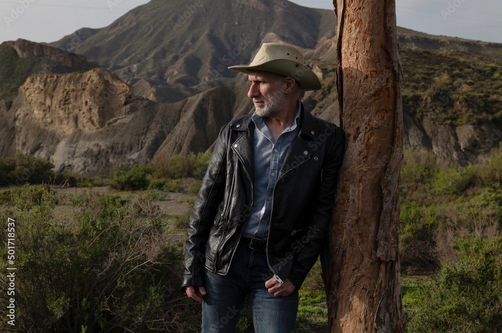 Adult man in cowboy hat in oasis of desert. Almeria, Spain Adult man in cowboy hat in oasis of desert. Almeria, Spain