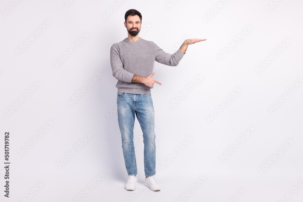 Full length photo of young man indciate fingers empty space ad promo choice isolated over grey color background Full length photo of young man indciate fingers empty space ad promo choice isolated over grey color background