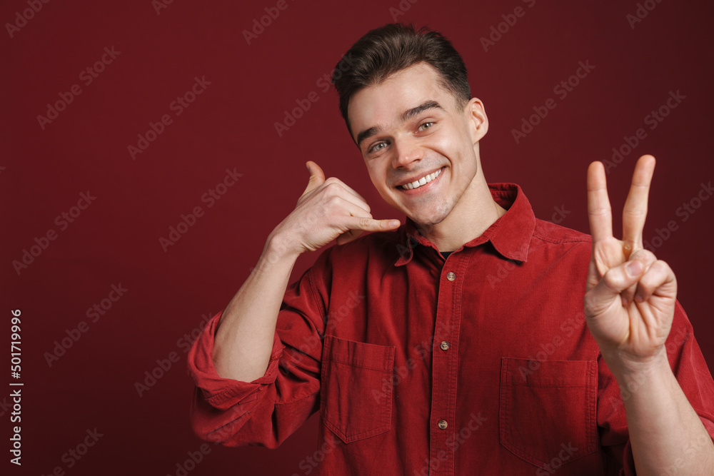 Young white man wearing shirt gesturing and smiling at camera Young white man wearing shirt gesturing and smiling at camera