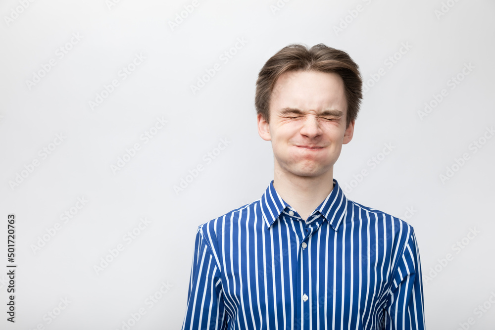 Young man with tightly closed eyes studio portrait Young man with tightly closed eyes studio portrait