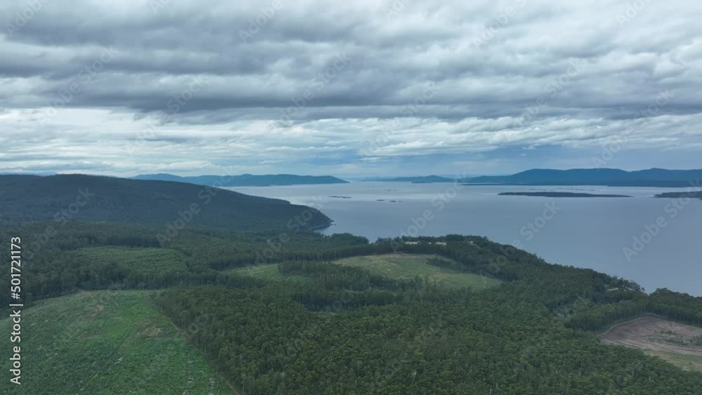 southern tasmania coastline, looking at bruny island with storm clouds and rain over the ocean, flying above a beach town and cattle, cow farm, in australia southern tasmania coastline, looking at bruny island with storm clouds and rain over the ocean, flying above a beach town and cattle, cow farm, in australia