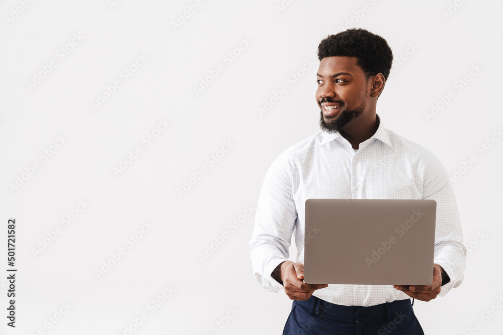 Black bearded man wearing shirt using laptop and smiling Black bearded man wearing shirt using laptop and smiling