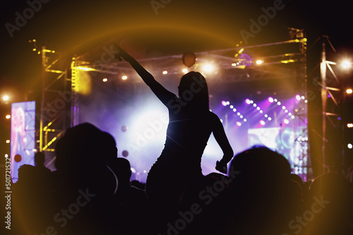 Girl on shoulders in the crowd at a music festival