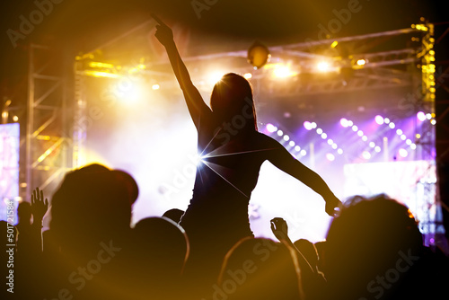 Girl on shoulders in the crowd at a music festival © 9parusnikov