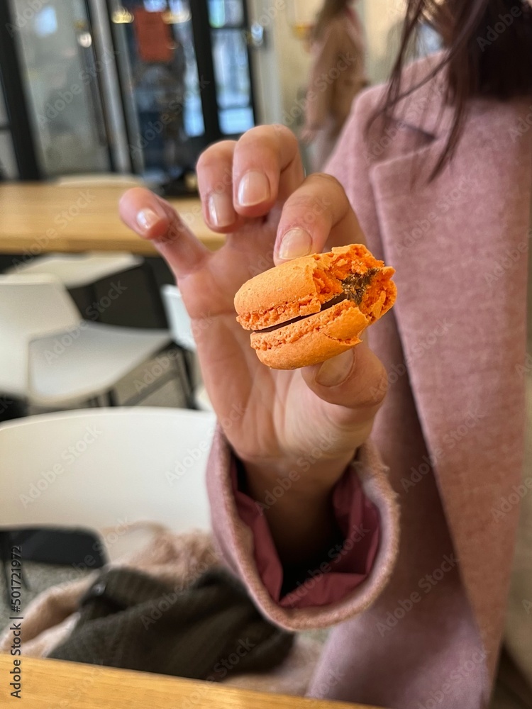 Fresh macaron in the woman's hand 