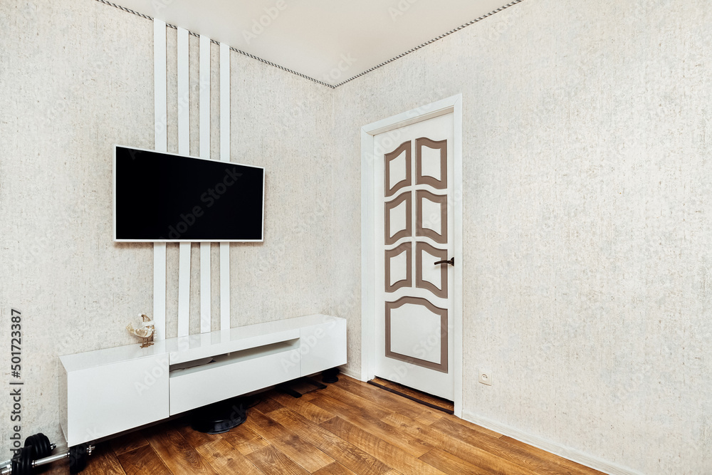 Fototapeta premium bright bedroom with a TV on the wall in the apartment