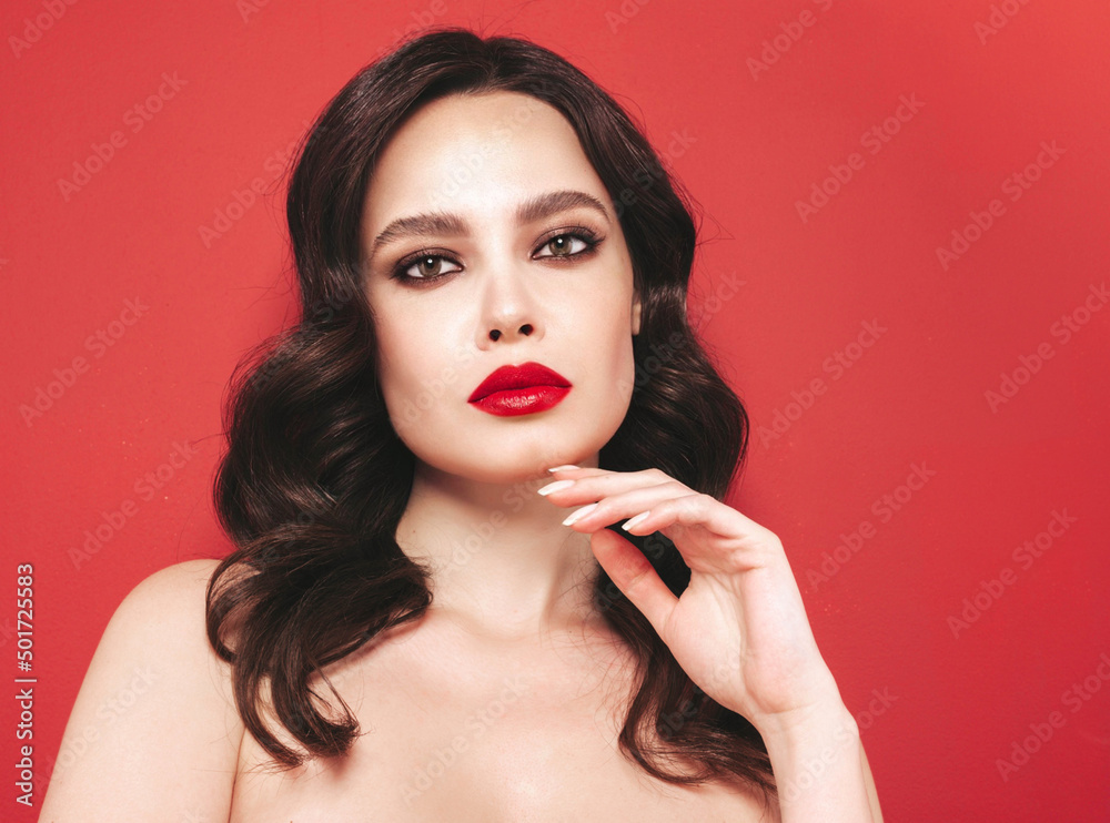 Beauty portrait of young brunette woman with evening makeup and perfect clean skin. Sexy model with curly hair posing in studio. With red bright natural lips. Isolated Beauty portrait of young brunette woman with evening makeup and perfect clean skin. Sexy model with curly hair posing in studio. With red bright natural lips. Isolated