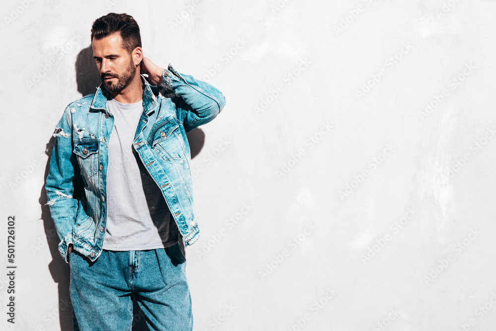 Portrait of handsome confident stylish hipster lambersexual model. Sexy man  dressed in jeans jacket. Fashion male isolated on grey wall in studio Stock  Photo | Adobe Stock