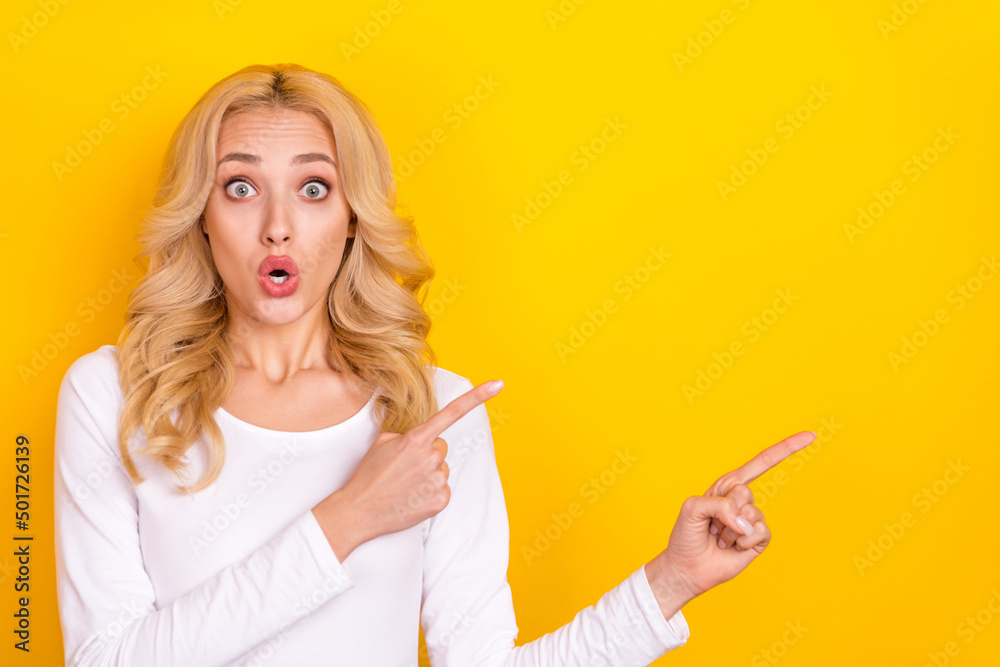 Photo of impressed funky lady dressed white shirt pointing empty space big eyes isolated yellow color background Photo of impressed funky lady dressed white shirt pointing empty space big eyes isolated yellow color background