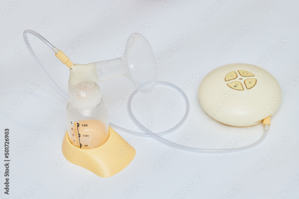 Breast pump with empty baby bottle on table Breast pump with empty baby bottle on table