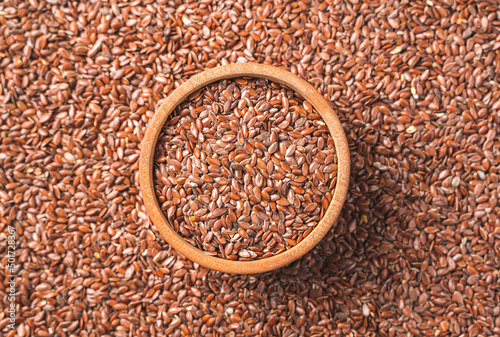 Flax seeds in a wooden bowl and on the background. Source of omega 3.