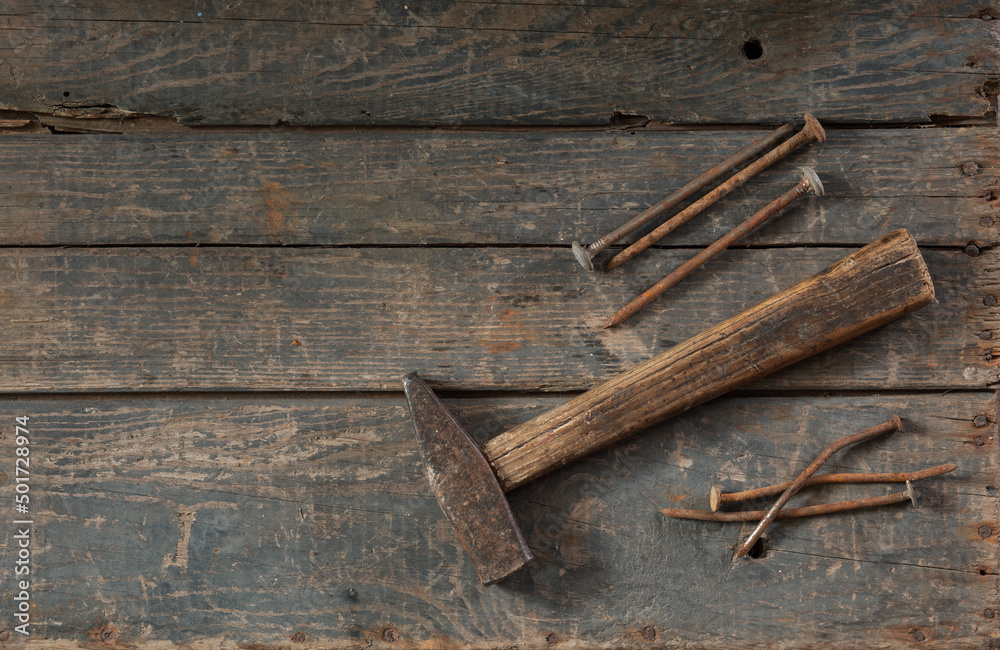 Old hammer and rusty nails on an old wooden box Old hammer and rusty nails on an old wooden box
