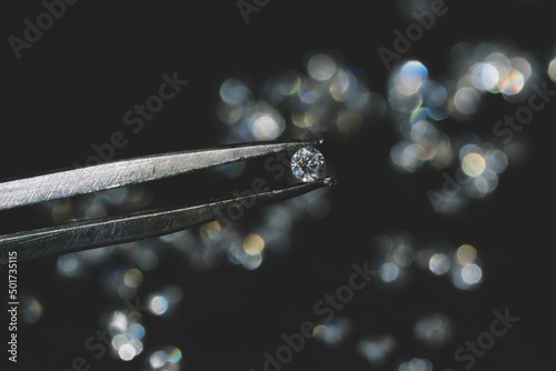 Canvas close up photo of round Diamond in Tweezers