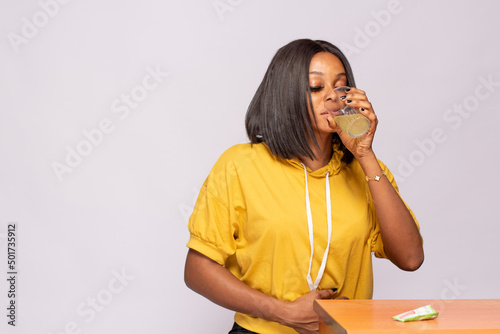 Fotografi african lady with upset stomach drinking a laxative