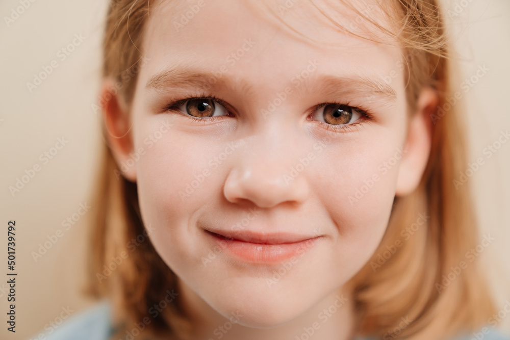 portrait of a cheerful little girl with blonde hair in a blue T-shirt. happy childhood. Emotions.