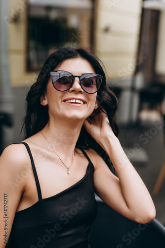 Close-up image of a beautiful young woman in black sunglasses.Against the background of coffee