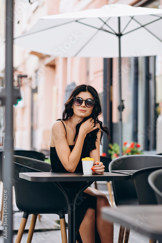 Young woman with coffee in a cafe on the street