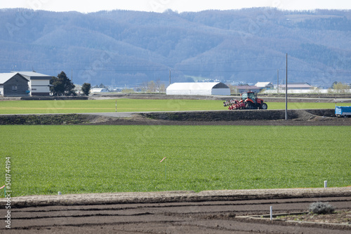 広大な北海道の牧草畑を耕すトラクター