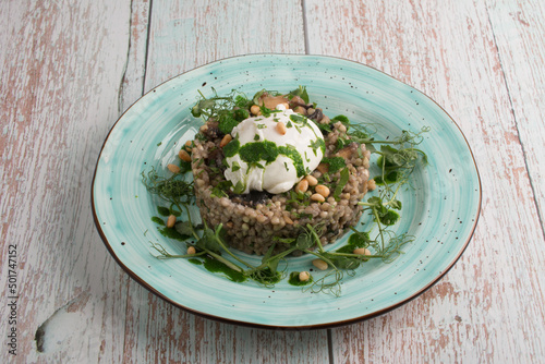 buckwheat porridge with poached egg and fried mushrooms, decorated with celery. A wonderful restaurant dish