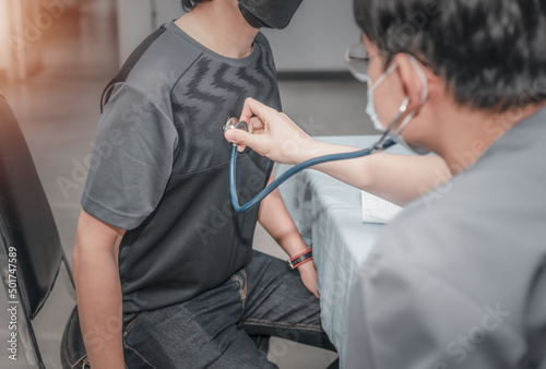 Doctor using a stethoscope checking patient and listen to the heartbeat patient.presenting results symptom and recommend treatment method, Healthcare and medical concept. 
