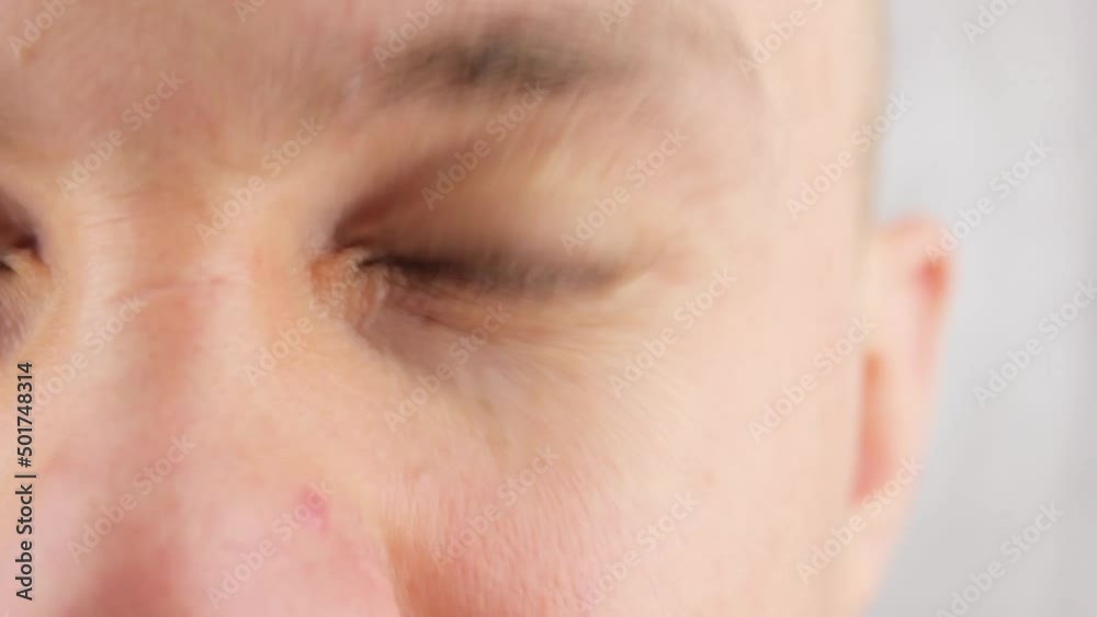 Blink an eye close-up. A man squeezes his eye blinks his eye. Blink an eye close-up. A man squeezes his eye blinks his eye.