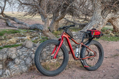 bike touring in Colorado prairie - fat mountain bike with a frame and trunk bag, early spring scenery in Soapstone Prairie Natural Area near Fort Collins
