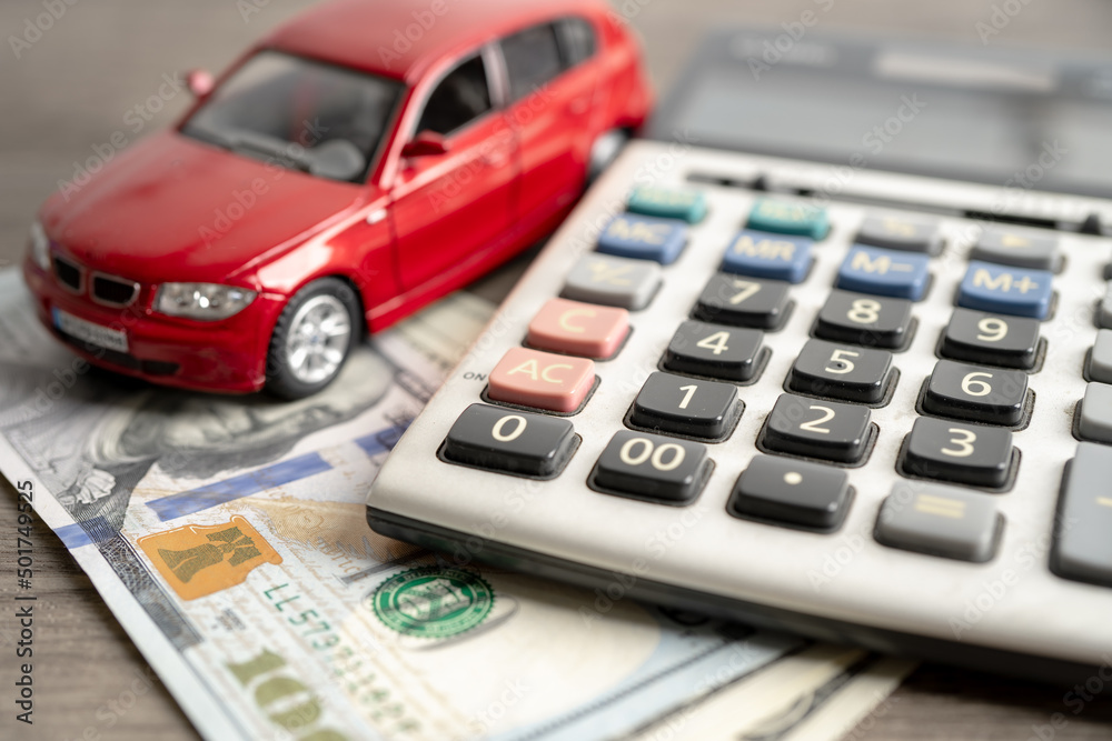 Car on US dollar banknotes and calculator, loan, Finance, saving money, insurance and leasing time concepts. Car on US dollar banknotes and calculator, loan, Finance, saving money, insurance and leasing time concepts.
