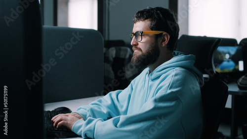 Web developer in glasses working on a computer in IT office