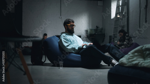 Male IT worker with a laptop working while sitting in a bomb shelter during the war